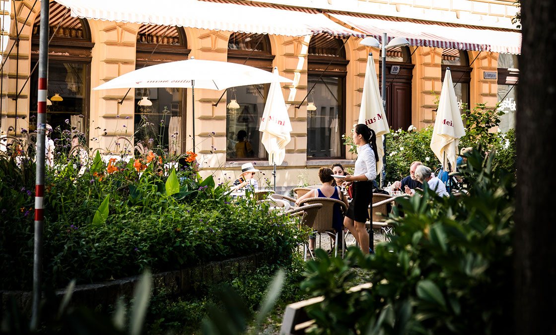 Gastgarten des Café Sperl mit Sonnenschirmen und Blumen