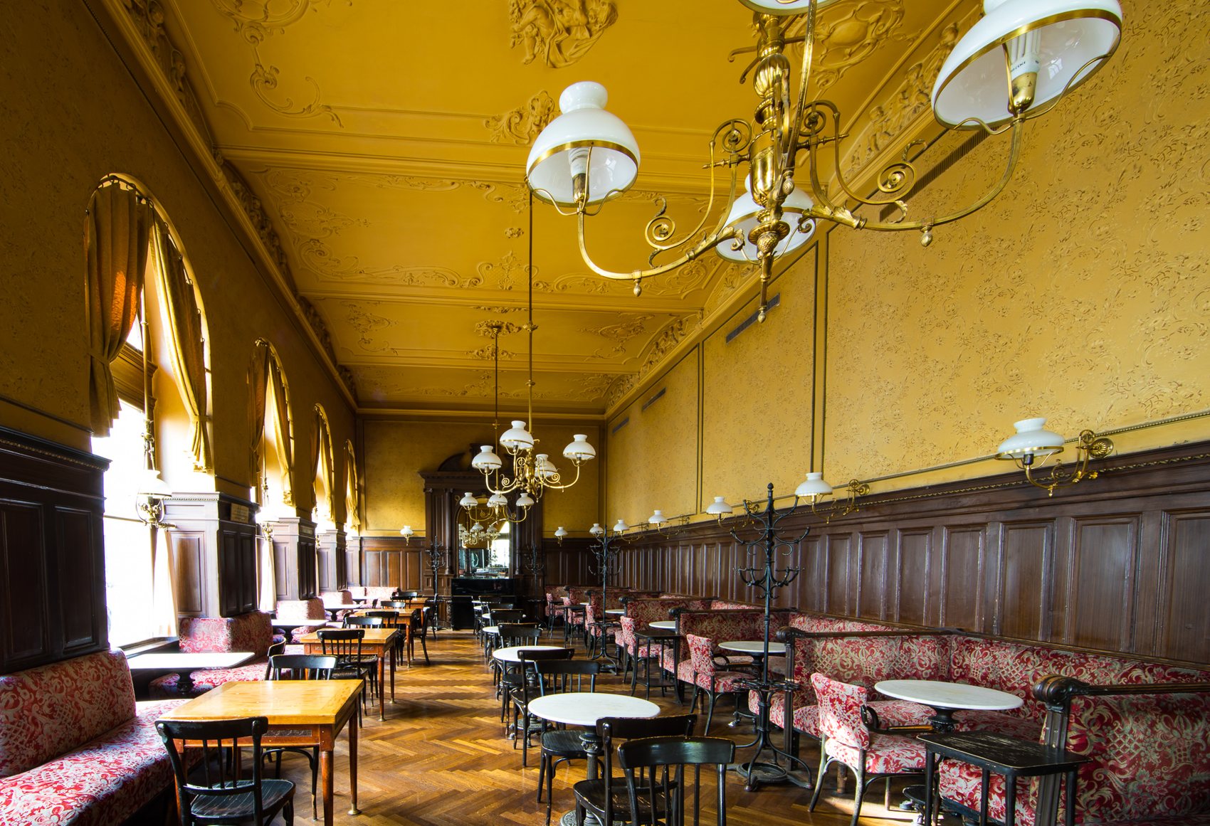Großer Saal des Café Sperl mit goldenen Wänden und Kristalllustern