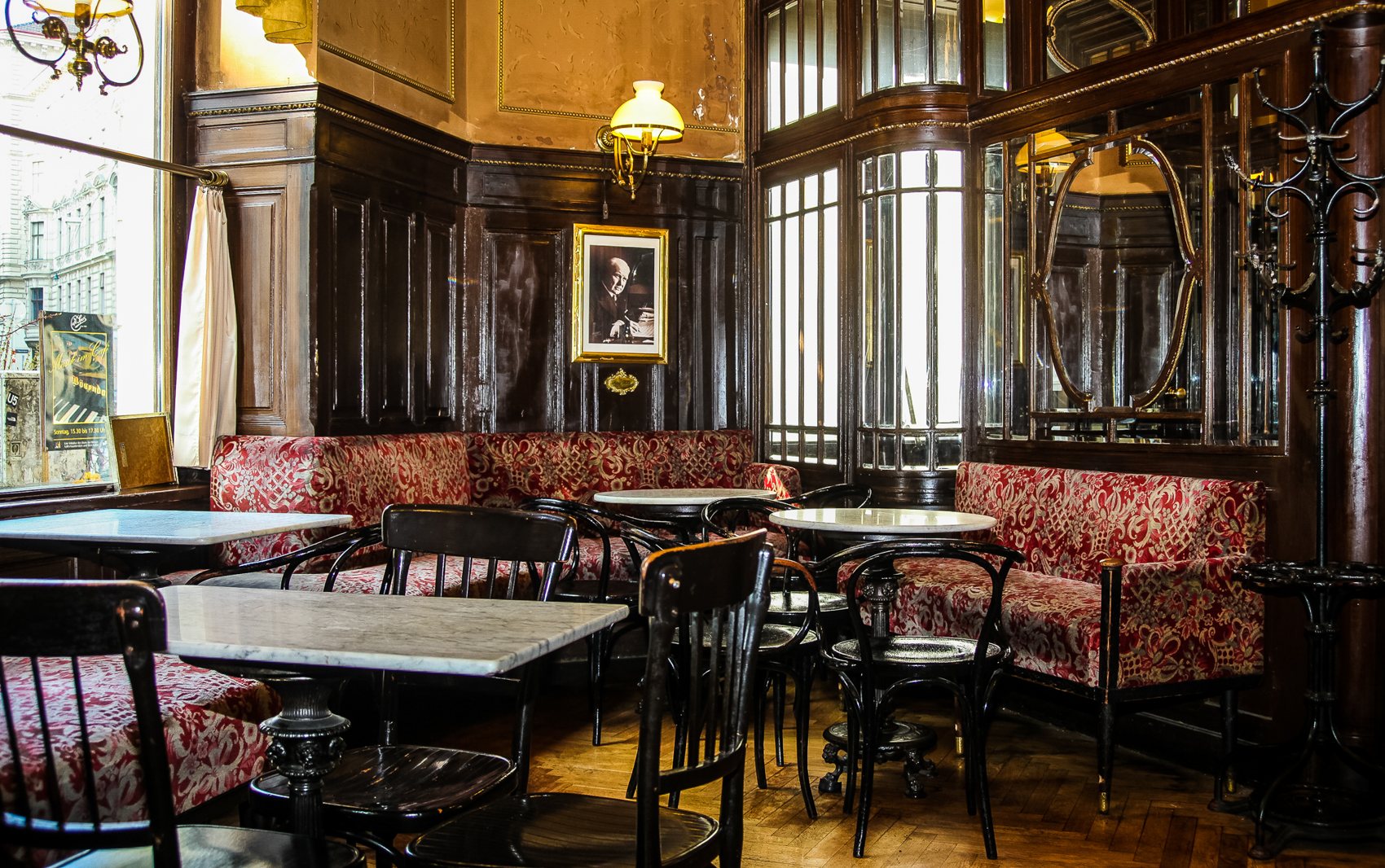 Gemütliche Ecke im Café Sperl mit roten Plüschbänken und Wandvertäfelung